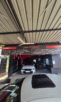 The workshop entrance in daylight with a white BMW parked inside beneath the service signage